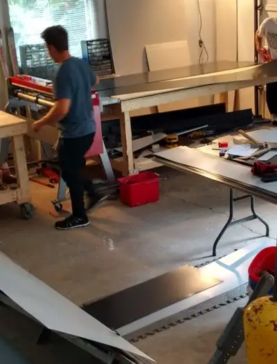 Sheet metal being formed on a brake in the Raymond Desrochers Roofing metal shop